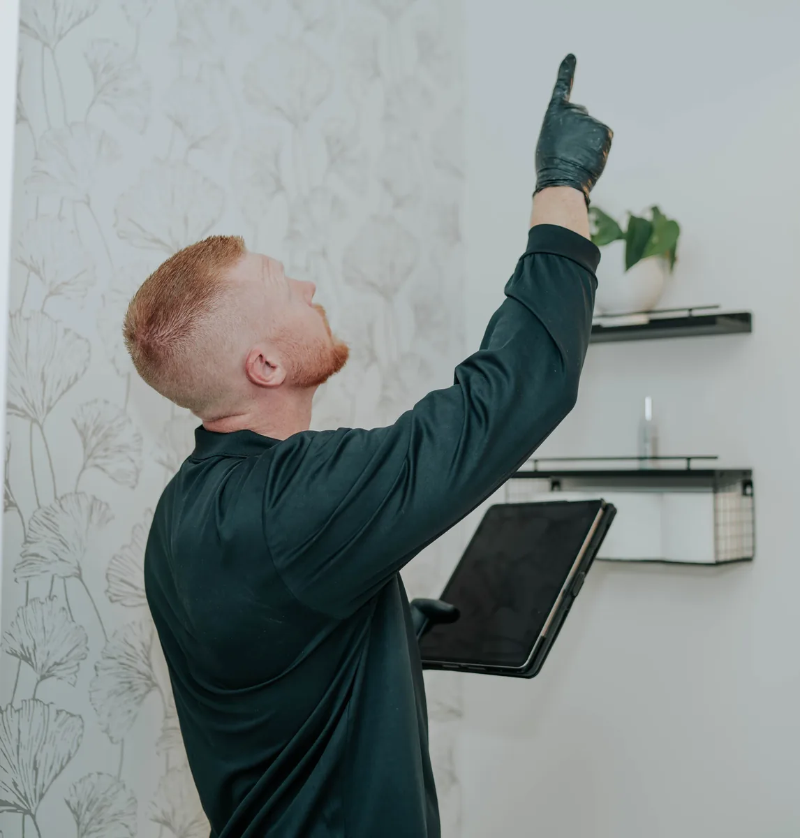 PureAire Technology technician inspecting a wall for mold in a Miami-Dade home